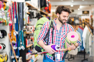 El hombre en la tienda de artículos deportivos compra de artículos para actividades al aire libre. (Imagen)