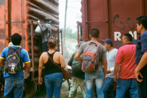 Migrantes y contrabandistas se reúnen en torno a "La Bestia" después de que el tren se detuvieran en Chiapas, México, cerca de la frontera con Guatemala. Los migrantes deben pagar $100 a los carteles mexicanos en varias paradas a lo largo del camino, haciendo el viaje muy costoso y, a menudo, imposible para ellos. Crédito de imagen: Jason De León.