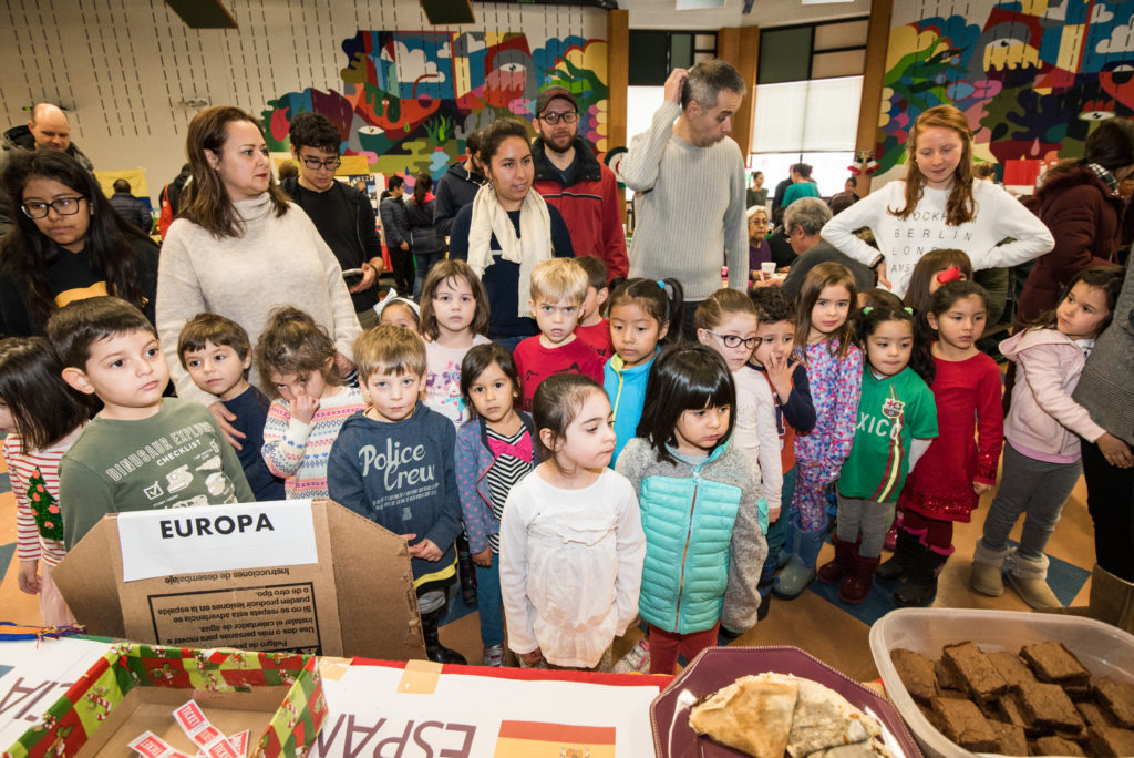 Estudiantes de En Nuestra Lengua pasan por las diferentes mesas en Bach Elementary durante la recaudación annual de fondos para el programa, que incluye la venta de comidas típicas de países de habla hispana.