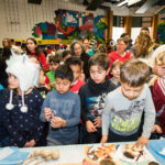 Estudiantes de En Nuestra Lengua pasan por las diferentes mesas en Bach Elementary durante la recaudación anual de fondos para el programa, que incluye la venta de comidas típicas de países de habla hispana.