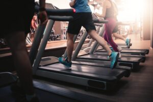 Personas usando caminadoras en un gimnasio. Crédito de la imagen: Adobe Stock.