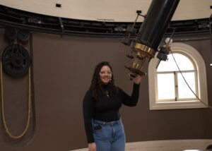 Marbely Micolta, estudiante de doctorado en la Universidad de Michigan, posa junto al telescopio refractor Fitz en el Detroit Observatory, en Ann Arbor, Michigan. Crédito de imagen: Vaishnav Rao